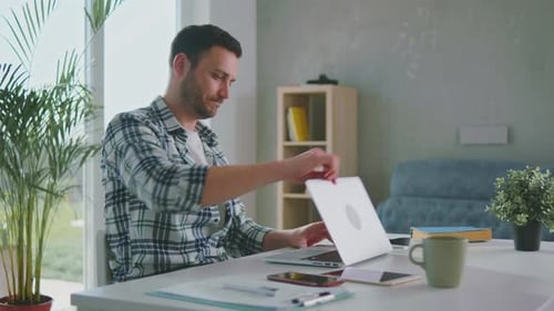 Young Man Working at Laptop in Home