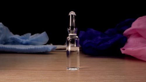 Glass Vial with Medical Items on Wooden Surface
