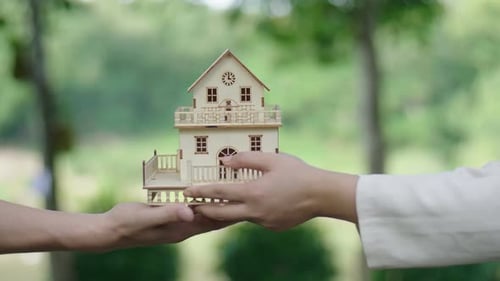 Giving Miniature House Model in Green Outdoor Setting