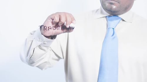Man Writing Trademark on Clear Surface