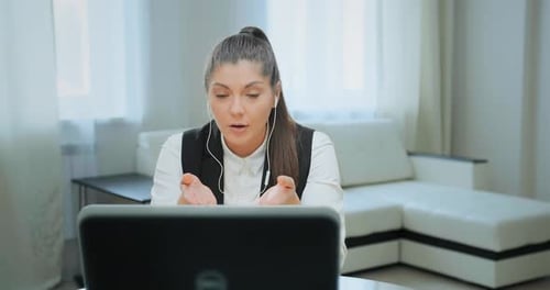 Woman Attends Online Meeting on Laptop at Home