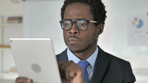 Young Adult Works on Tablet in Modern Office