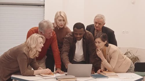 Diverse Team Collaborating on Laptop in Office
