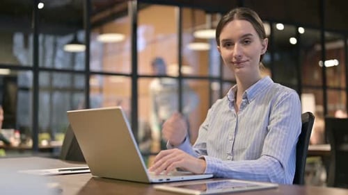Woman Working at Laptop Gives Thumbs Up