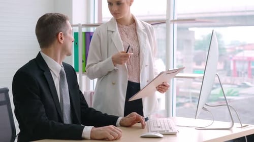 Two Business People Talk Project Strategy at Office