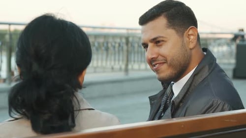 Man and Woman Conversing on Bench Outdoors