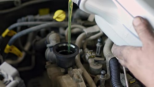 Pouring Fresh New Oil Into Car Engine In Repair Shop 2