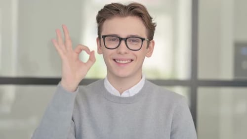 Young Adult Makes Ok Hand Gesture and Smiles