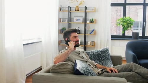 Young Adult Chatting on Phone on Couch at Home