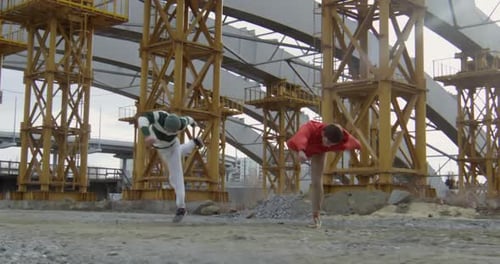 Acrobatic Capoeira Performers Practice Under Unfinished Bridge