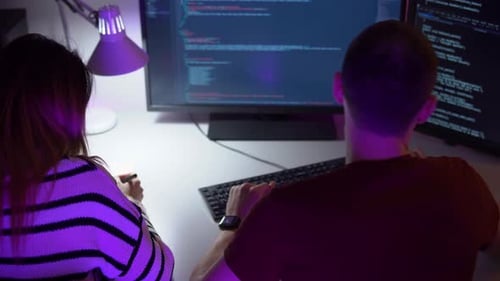 Coders Collaborating on Computer Programming at Desk