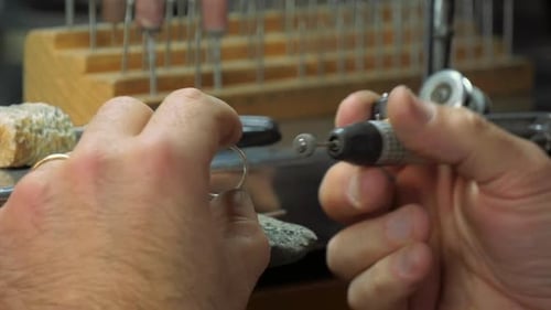 Goldschmiedehand poliert einen Ring
