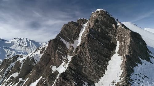 Dramatic Mountain Peaks Under a Cloudy Sky in Winter