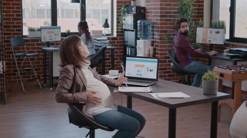 Femme d'affaires attend un enfant travaillant sur l'analyse avec un collègue