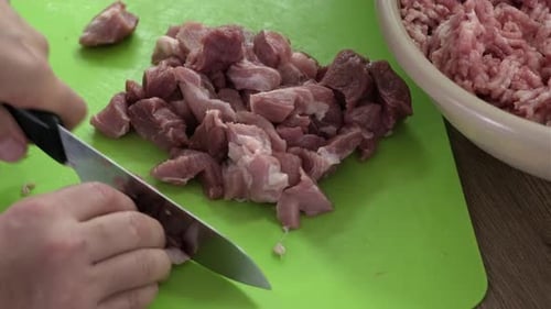Close Up View of Pork Meat Being Cut into Cubes