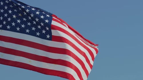 Worn American Flag Waving Proudly in the Wind