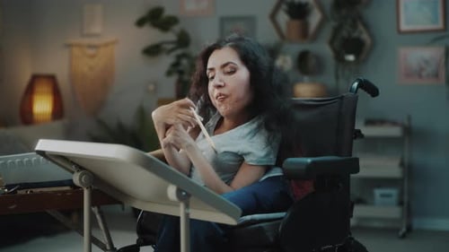 Woman in Wheelchair Indoors Holding Item
