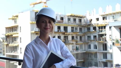 young engineer woman with helmet and tablet on building.