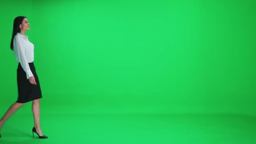 Young Businesswoman in a Suit Walks on a Green Background Chroma Key Template
