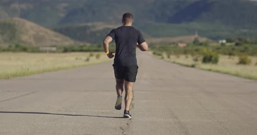 Rear or Back View of Jogger During Intense Training in the Morning