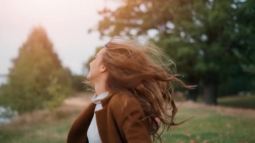 The Happy Young Woman Is Dancing and Jumping in the Forest. The Pretty Girl Is Running and Smiling