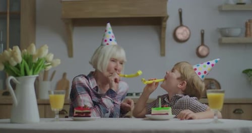 Grandmother and Grandson Celebrate Birthday with Cake and Horns