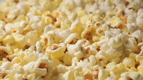a Close-up of Newly Cooked Popcorn Rotating in a Popcorn Dispenser