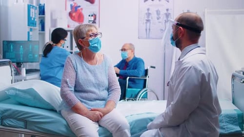 Doctor Consults with Senior Patient in Hospital