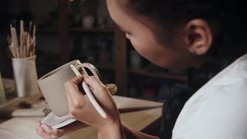 Young Adult Crafting Ceramic Mug in Studio