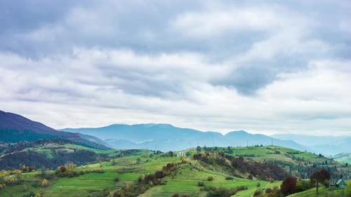 Landscapes of Green Hills Under a Layer of White and Fluffy Clouds