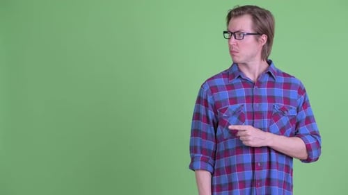 Junger gutaussehender Hipster-Mann zeigt zur Seite