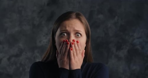 Emotional Woman Experiences Surprise and Horror Opens Her Eyes Wide and Covers Her Open Mouth with