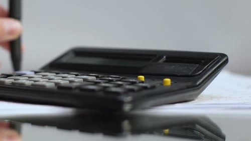 Médico calculando el precio del tratamiento, quitándose los anteojos, el resultado del ecg en la mesa