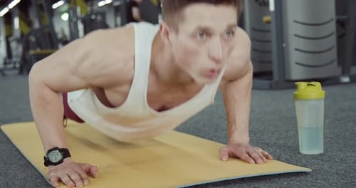 Athletic Man Doing Push Ups at the Gym
