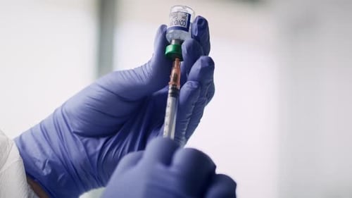 Vídeo de manos humanas con medicamento contra el coronavirus y una jeringa. Fotografiado con cámara de helio RED