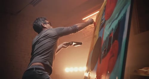Male Artisan Creating Abstract Portrait Illuminated Studio