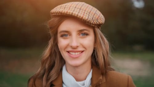 The Young Girl Is Smiling in a Forest and Is Looking at Camera