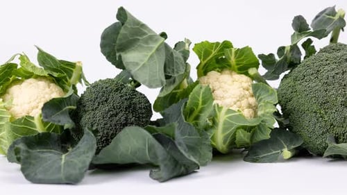Fresh Broccoli and Cauliflower on White Surface