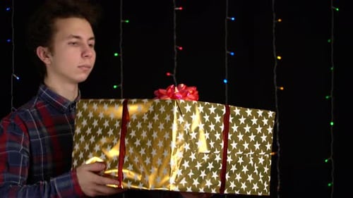 Young Man Holds Large Gold Birthday Gift