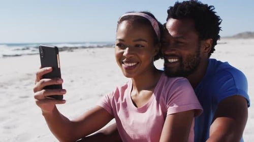 African american couple smiling taking selfie with smartphone on the beach