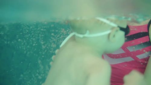 Close Up of a Beatutiful Young Woman Playing and Diving with Her Son in a Closed Swimming Pool