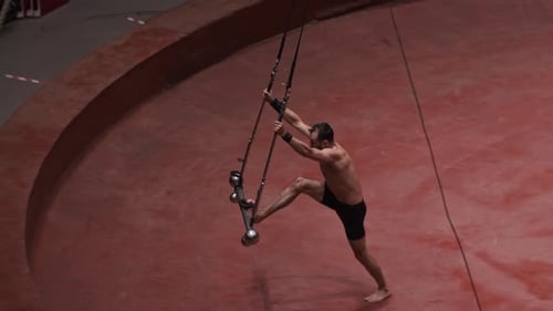 An Acrobatic Man About to Do a Show on the Flying Construction Swinging the Construction