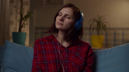 Woman Listening to Music on Headphones at Home