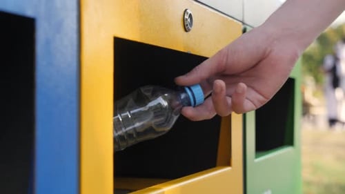 Hand Recycling Plastic Bottle in Urban Setting
