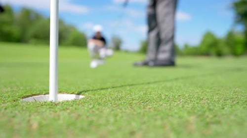 Golf Ball Rolling into the Hole on Green