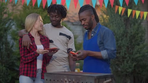 Friends Enjoying Summer Barbecue in Backyard Setting