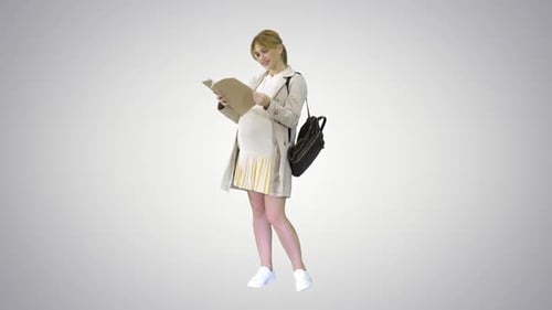 Pregnant Woman Reads Folder Standing on Light Background