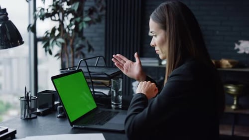 Business Woman Calling Video on Laptop Computer with Green Screen in Office