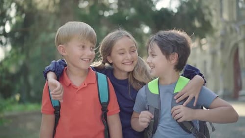 Three Smiling Children Embracing in Front of School