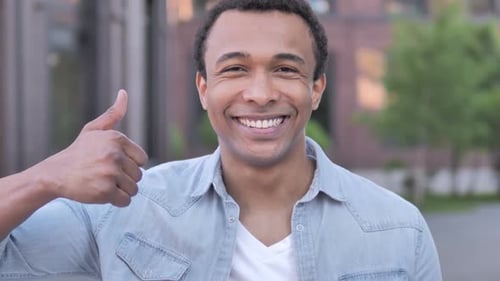 Smiling Man Gives Thumbs Up Approval Gesture